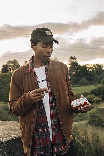 A photograph of a man holding a cigarette and beer.