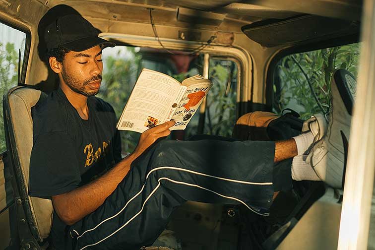 A photo of a man in a car reading.