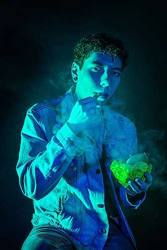 A portrait capturing ‘Liam’ in his natural state, vaping and eating a McChicken.