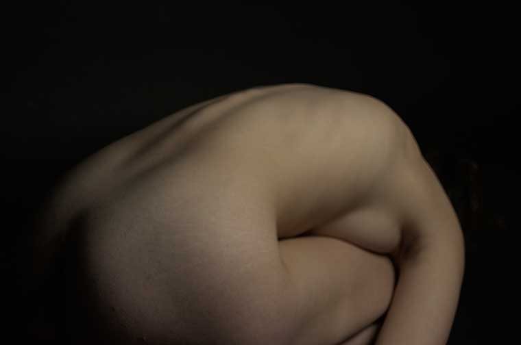Weary is a horizontal photo that shows the woman curled up into what can be best described as an egg, You can see the spine being stretched and the head faded into nothingness. 