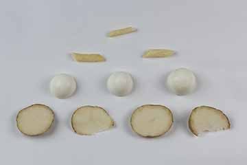 Photograph of a small piece of a french fry, two pieces of pasta, three halves of hard-boiled eggs, and four slices of raw potato in a pyramid formation.