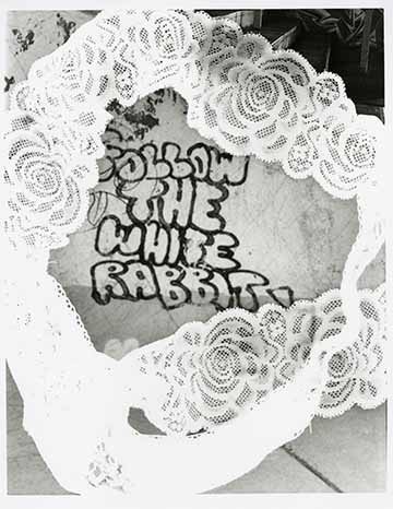 Graffiti saying ‘Follow the white rabbit’ with a white lace thong placed over it.