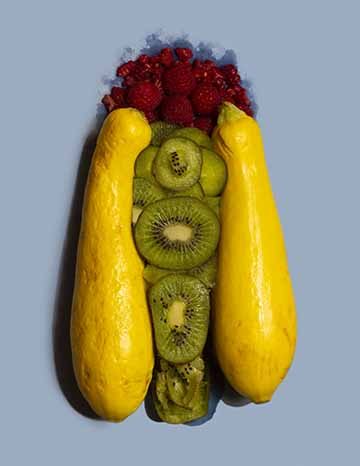 A vagina depicted with two yellow squash, kiwis, and pomegranate 