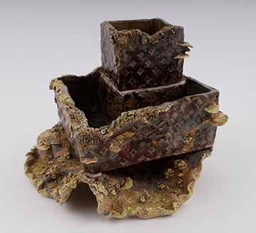 A stack of planters; cube on top, larger square in the middle, and wavy plate shape on the bottom. The surface is mottled brown, green and yellow. There is a subtle diamond pattern pressed onto the surfaces. This is obscured by fungal forms coming out of the surface. Fungal forms include flat discs, small orbs, wormy shapes, and pitted texture.