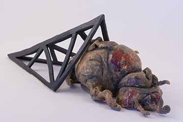 Image a: Two forms. The furthest back is black and geometric. It is made of triangles and forms a sort of pyramid cage with one open side. In front of that form, and coming out of the open side, is a blobby brown and black form. It is covered in folds and tentacles. It has black bits sticking off of it that match the surface of the geometric form it is exiting. The composition is diagonal from middle left to lower right.