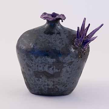 ​​​​​​​Image b: The same vase from the opposite side. In this image the grouping on the shoulder of the vase is on the right side of the image. The mottled surface and colors are consistent with the other view.