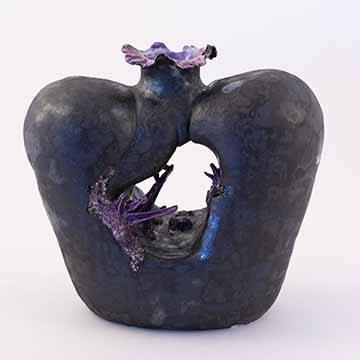 Image a: A black vase with purple crystal forms growing out of it. The vase is narrow at the bottom, wide at the shoulder, and closes to a very thin neck with an undulating rim. There is a large whole through the center of the vase where glossy purple crystals appear from folds in the surface. The black surface is mottled matte and metallic. The inside of the rim and the crystals are the same glossy purple.