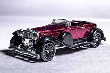 4 photographs of toy cars made to look like real cars. Each photo depicts a different car in an environment. Photo one depicts a car from the 1930’s in a dark, noir styled scene. Photo two depicts a rally car in the desert. Photo three depicts a suped up 1950’s truck. Photo four depicts a 1920’s car in a winter scene.