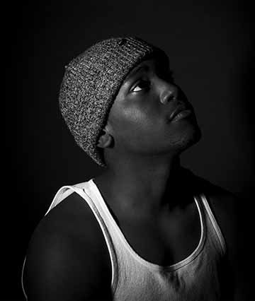 “Cyrus” is a black and white large format portrait photograph. The overall gentle feel of this photo goes along with Cyrus as a person. The heavy contrast throughout the figure and his clothing, along with the bright highlights helps define the subject from the all black background. The dark shadows on the figure also help bring out the figure profile without being overpowering. The soft upward gaze from the model helps give a narrative to the piece which is open for interpretation.