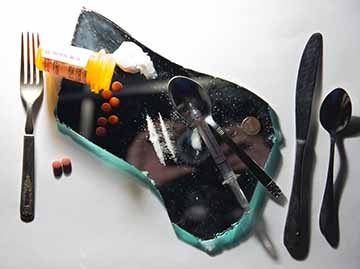 “It’s What’s For Dinner” is a piece created in regard to addiction and substance abuse. The scene as a whole is designed to look like a meal on a dinner plate, but instead of a plate there is a piece of a broken mirror, and instead of food there are multiple different drugs. This concept is that addiction for drugs is just as powerful as the need for food, or possibly even more. 