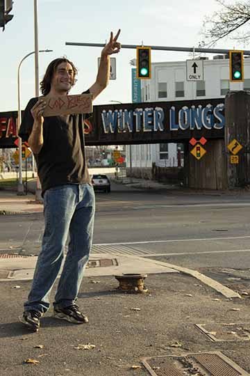 “Christian” is a piece as well as an individual used in a series titled “Faces Around Town”. This series was created to document some of the homeless community in downtown Syracuse, New York. This photo shows Christian in one of his regular working locations. His expression and pose in the photo are a great representation of Christians happy, positive attitude. The photo uses natural lighting and is taken in an urban environment to help show the area where Christian prefers to work. 