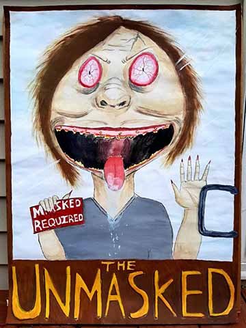 In this image is a deranged lady who is holding up a sign that says “maks required”, she has her mouth open as she’s licking the window of a door. On the door it says the title The Unmasked. 